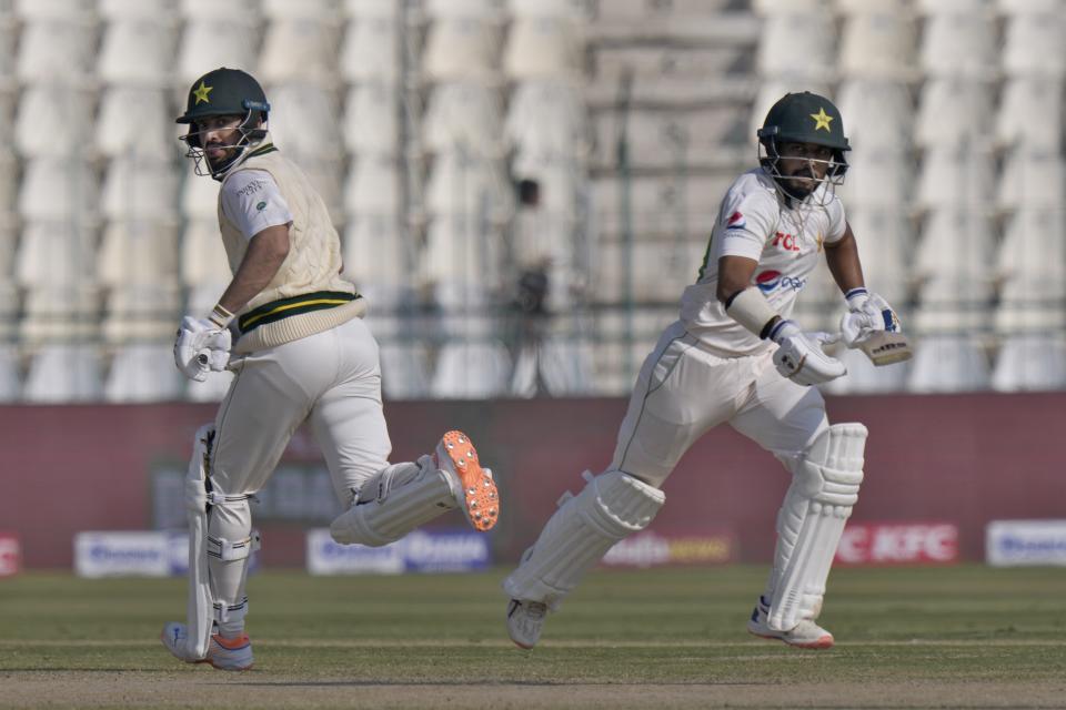 Pakistan's Mohammad Nawaz, left, and Saud Shakeel run between the wickets during the fourth day of the second test cricket match between Pakistan and England, in Multan, Pakistan, Monday, Dec. 12, 2022. (AP Photo/Anjum Naveed)