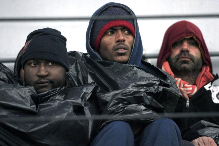 Migrants wait to disembark from a ship on February 17, 2015 in the port of Porto Empedocle, south Sicily, following a rescue operation of migrants as part of the International Frontex plan