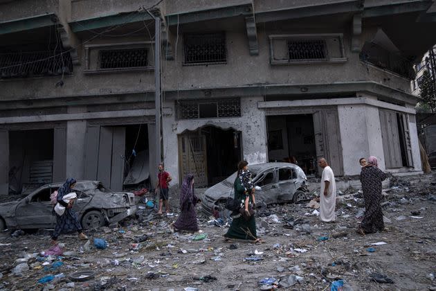 Palestinians walk amid the rubble following Israeli airstrikes that razed swaths of a neighborhood in Gaza City, Tuesday, Oct. 10, 2023. The militant Hamas rulers of the Gaza Strip carried out an unprecedented attack on Israel Saturday, killing over 900 people and taking captives. Israel launched heavy retaliatory airstrikes on the enclave, killing hundreds of Palestinians. (AP Photo/Fatima Shbair)