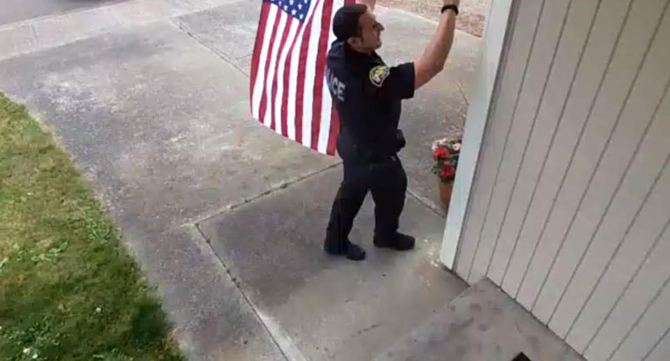 The officer adjusts the fallen flag, humbling resident Ben Rieman who was out celebrating the 4th of July. Source: Ben Rieman