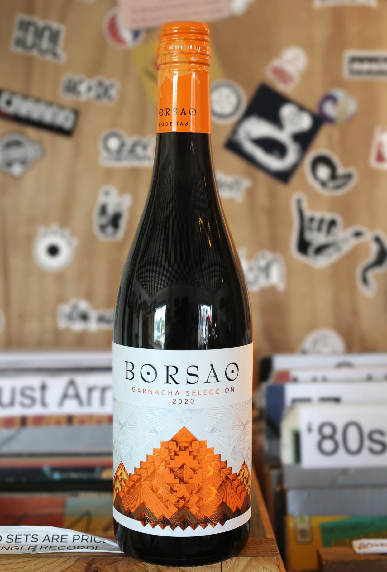 An $11.99 bottle of Borsao Garnacha Seleccion rests on a stack of vinyl albums in the Jenks Building billiard room in Cuyahoga Falls.