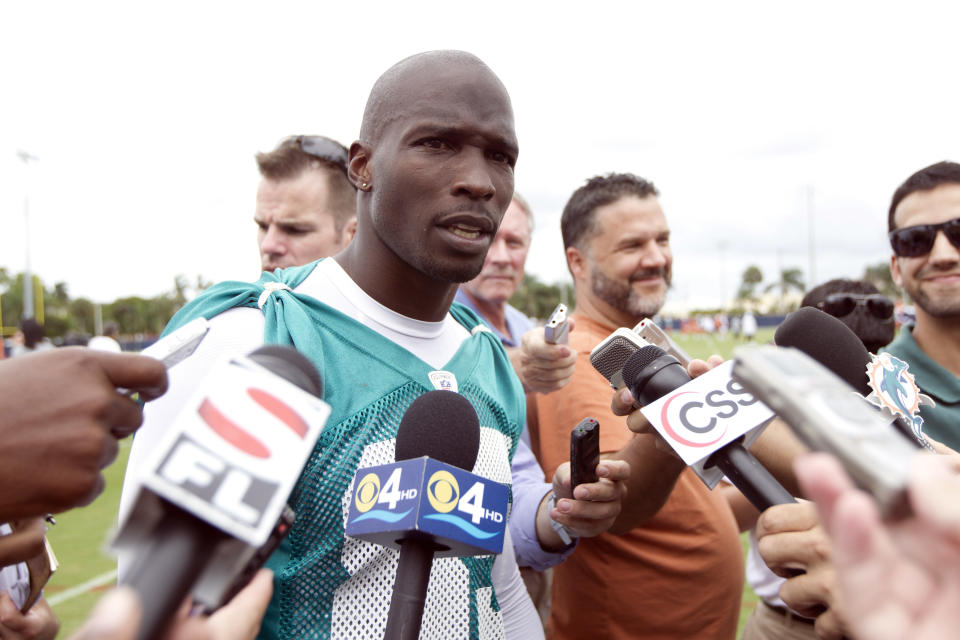 FILE - This June 19, 2012 file photo shows Miami Dolphins player Chad Ochocinco, who recently changed his name back to Chad Johnson, talking to the media after NFL practice in Davie, Fla. The Dolphins terminated the six-time Pro Bowl receiver's contract about 24 hours after he was arrested in a domestic battery case involving his wife. Johnson was released from jail on $2,500 bond earlier Sunday, Aug. 12, 2012, after his wife accused him of head-butting her during an argument in front of their home. (AP Photo/J Pat Carter, File)