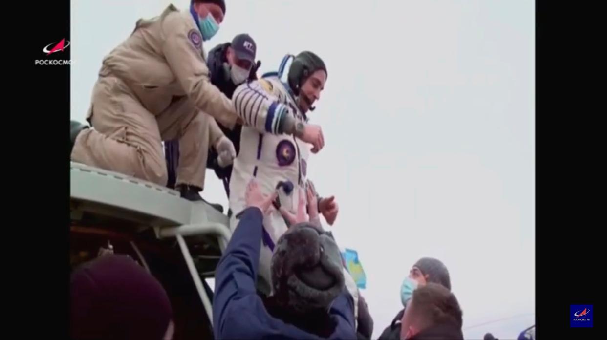 Ground personnel help Nasa astronaut Chris Cassidy and two Russian cosmonauts after they touch down on Earth (EPA)