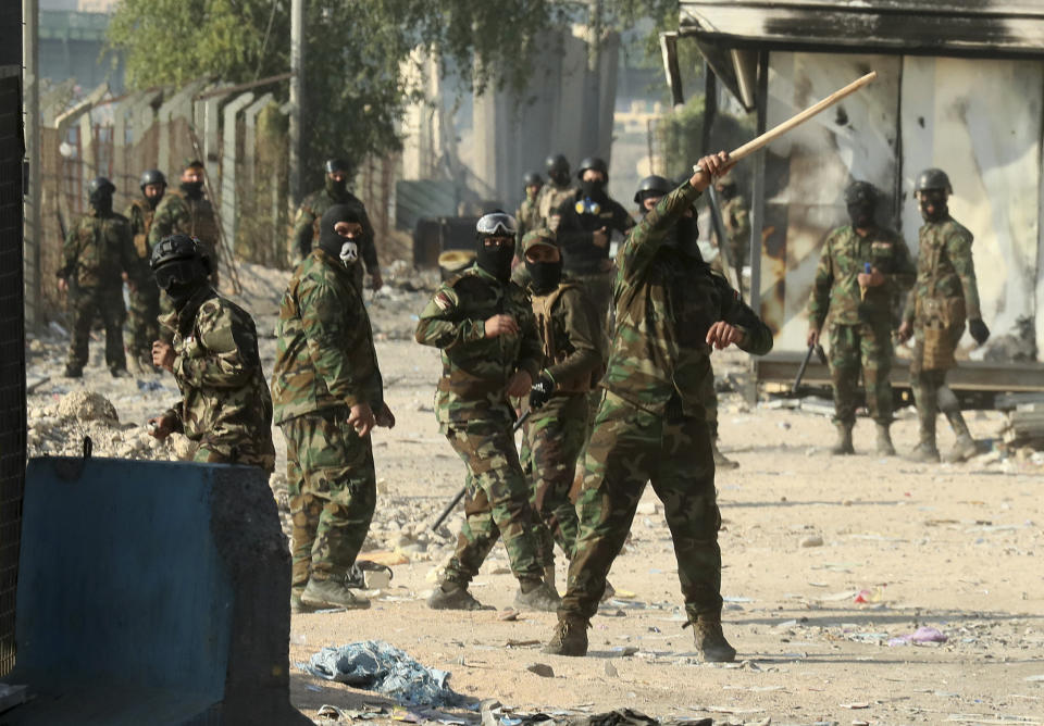 Security forces try to disperse anti-government protesters during clashes in Baghdad, Iraq, Saturday, Nov. 30, 2019. (AP Photo/Hadi Mizban)