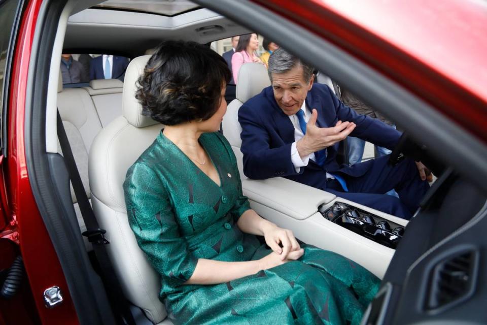 VinFast CEO Le Thi Thu Thuy and Gov. Roy Cooper sit inside a VF8 electric car outside the Raleigh Convention Center following an announcement that the company will build a manufacturing facility in Chatham County in March 2022.