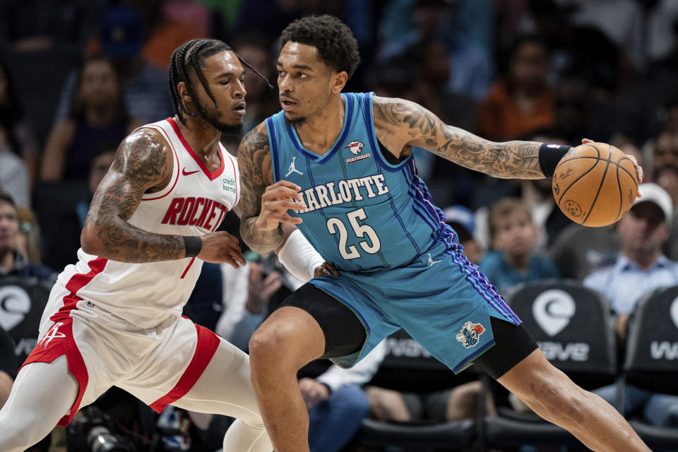 Houston Rockets forward Cam Whitmore (7) guards Charlotte Hornets forward P.J. Washington (25) during the first half of an NBA basketball game Friday, Jan. 26, 2024 in Charlotte, N.C. (AP Photo/Jacob Kupferman)