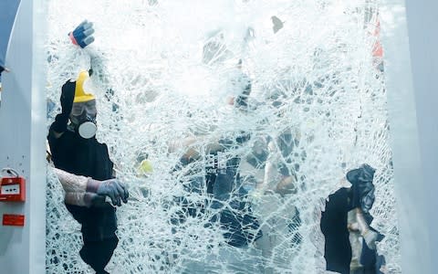 Protesters break the windows of the Legislative Council - Credit: Thomas Peter/Reuters