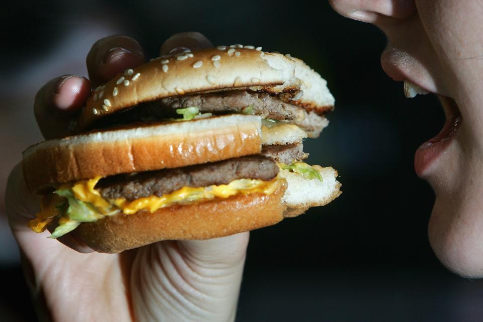 A woman eats a Big Mac burger.