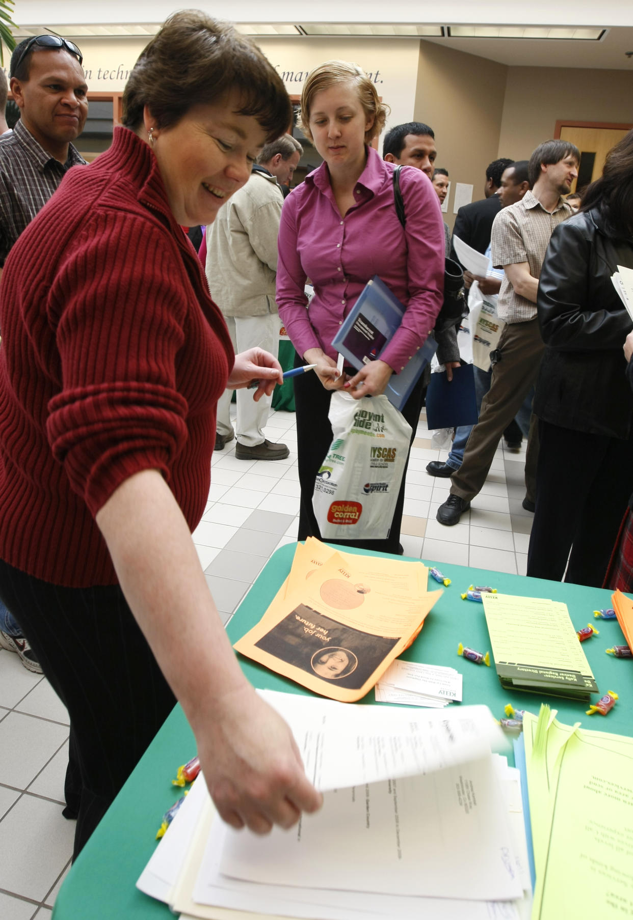 Bobbi Brown (L), senior staffing supervisor for Kelly Services, takes a resume from job seeker Crystal Haigh (C) at the Employment Guide job fair in Westminster, Colorado February 18, 2009. Hundreds of unemployed people came to the fair looking for work.   REUTERS/Rick Wilking (UNITED STATES)