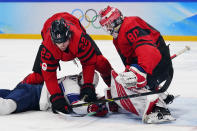 Canada goalkeeper Eddie Pasquale (80) and Owen Power (22) stop United States' Nathan Smith from reaching the puck during a preliminary round men's hockey game at the 2022 Winter Olympics, Saturday, Feb. 12, 2022, in Beijing. (AP Photo/Matt Slocum)