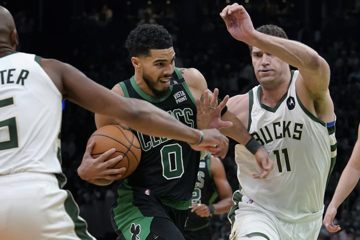 Boston Celtics forward Jayson Tatum (0) tries to drive past Milwaukee Bucks guard Jevon Carter, left, and center Brook Lopez (11) in the second half of Game 1 in the second round of the NBA Eastern Conference playoff series, Sunday, May 1, 2022, in Boston. (AP Photo/Steven Senne)