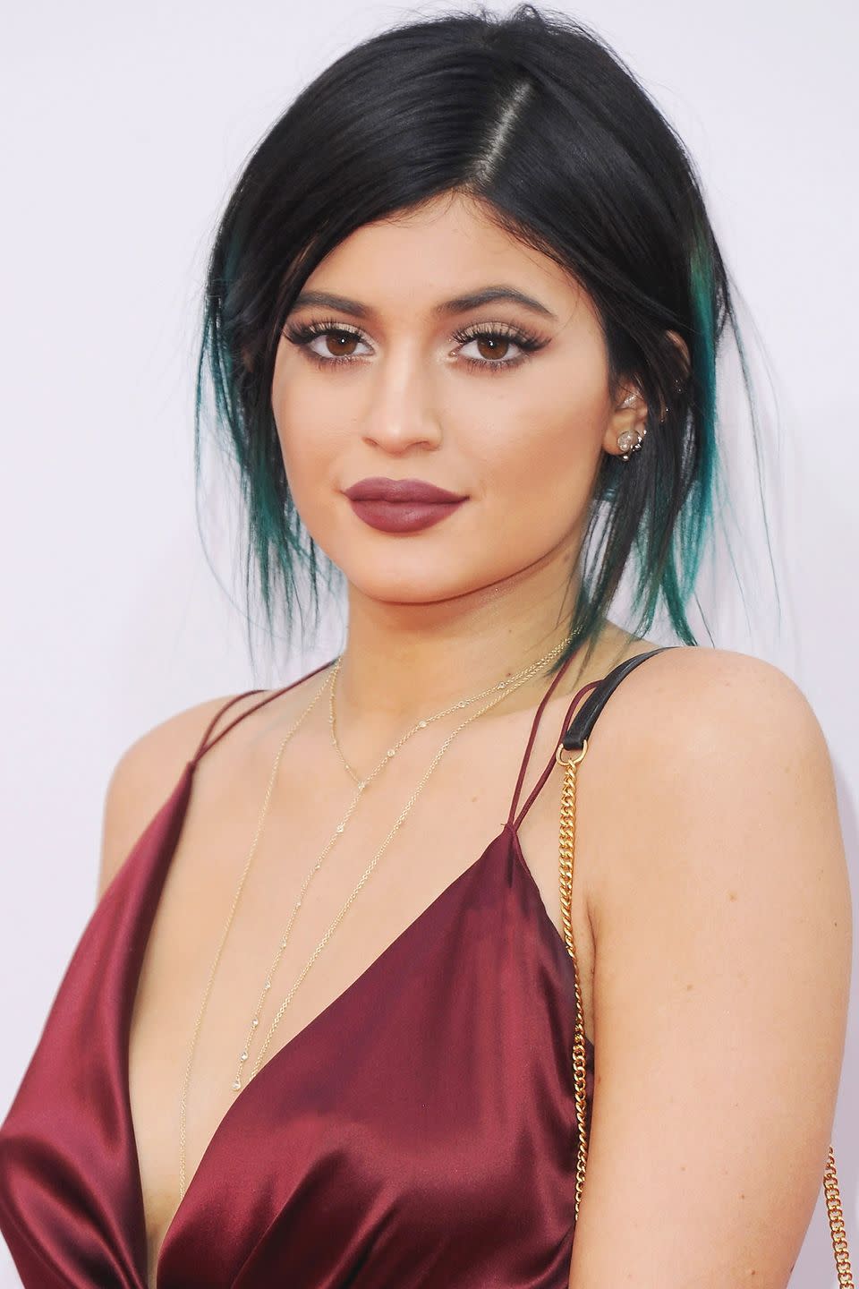 <p>Berry lipstick and teal extensions pulled back into a messy bun in 2014.</p>