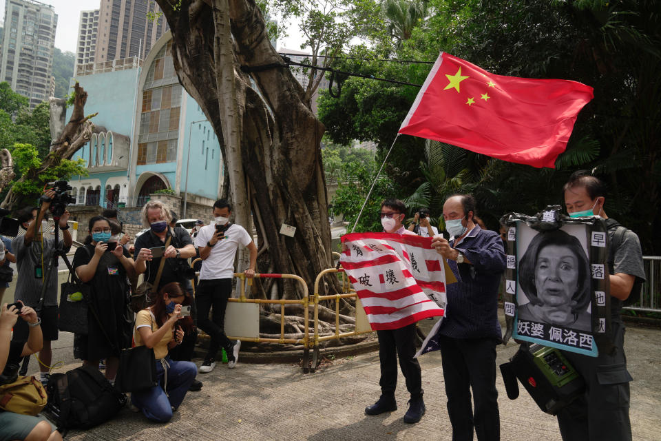 Pro-China supporters hold U.S. flag and a picture of U.S. House Speaker Nancy Pelosi during a protest outside the Consulate General of the United States in Hong Kong, Wednesday, Aug. 3, 2022. U.S. House Speaker Nancy Pelosi arrived in Taiwan late Tuesday, becoming the highest-ranking American official in 25 years to visit the self-ruled island claimed by China, which quickly announced that it would conduct military maneuvers in retaliation for her presence. (AP Photo/Kin Cheung)