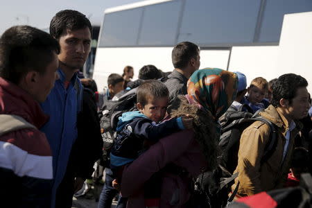 Refugees and migrants wait to board a bus heading to the borders of Greece with Macedonia, following their arrival on the Blue Star Patmos passenger ship, at the port of Piraeus, near Athens, Greece, October 6, 2015. REUTERS/Alkis Konstantinidis