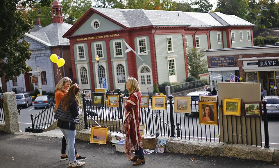 Hingham artist Lauren Bass, center, talk with prospective buyers on Sunday Oct. 14, 2018.