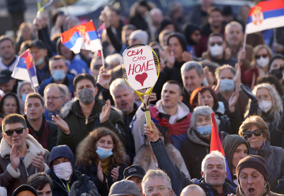 A supporter of Serbia's Novak Djokovic holds a banner that reads: ''We all are Nole (Novak)'' during protest in Belgrade, Serbia, Friday, Jan. 7, 2022. Several hundred people gathered outside Serbian parliament in a show of support for Serbian player Novak Djokovic as he battles the Australian legal system in an attempt to be allowed to stay in the country and compete in the Australian Open later this month. (AP Photo/Darko Vojinovic)