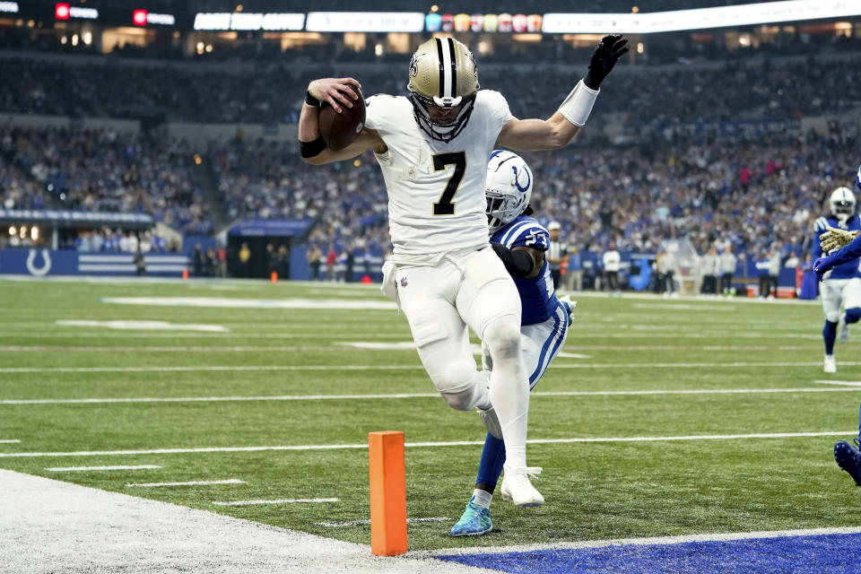 New Orleans Saints quarterback Taysom Hill (7) scores on a 20-yard touchdown run as Indianapolis Colts cornerback Kenny Moore II (23) defends during the first half of an NFL football game Sunday, Oct. 29, 2023 in Indianapolis. (AP Photo/Michael Conroy)