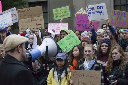 Eastside Catholic High School students listen to Shaun Knittel of Social Outreach Seattle speak during a rally he organized in support of the Eastside Catholic's former Vice Principal Mark Zmuda at the Archdiocese of Seattle chancery building in Seattle, Washington, December 20, 2013. REUTERS/David Ryder