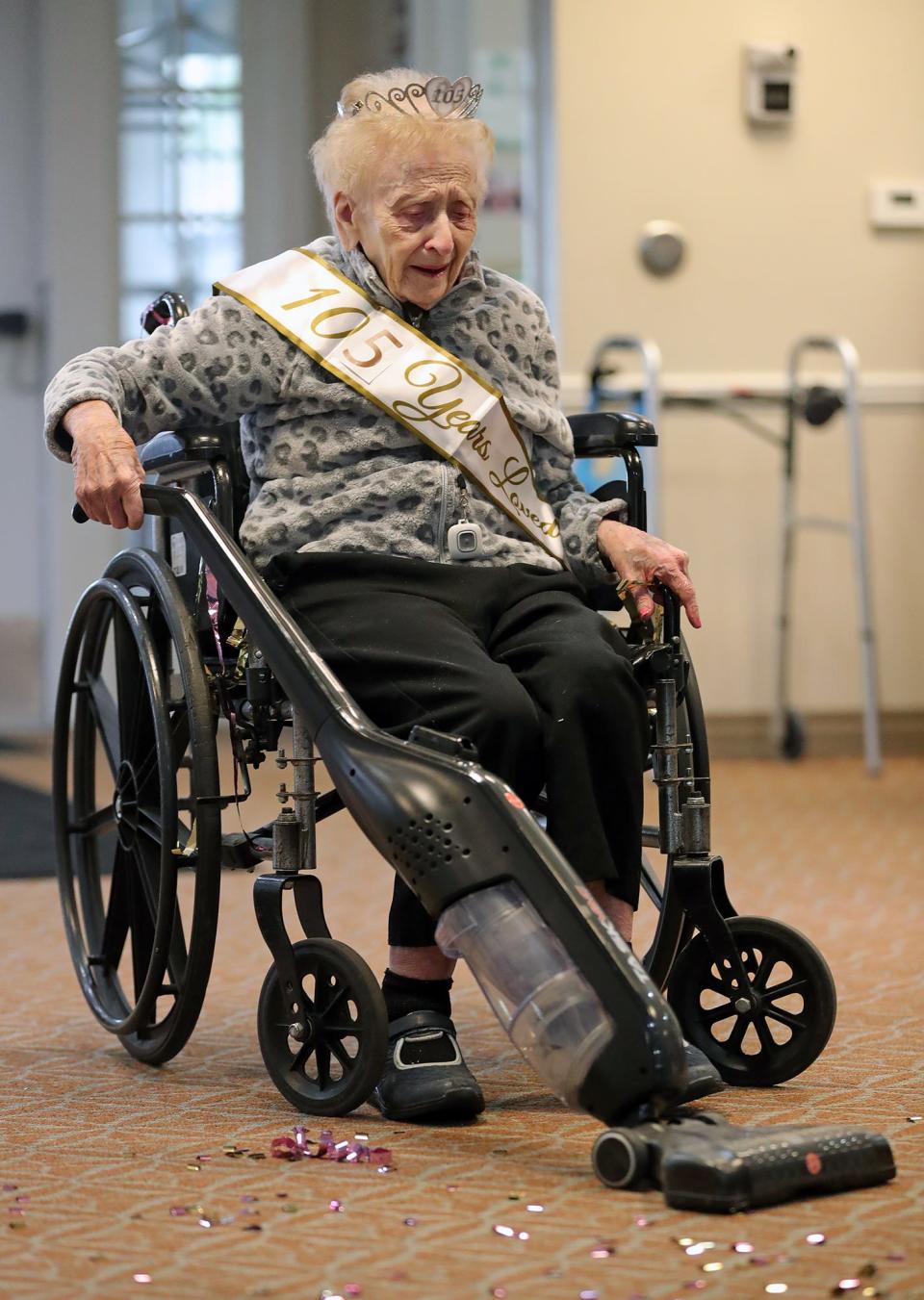 Helen Molnar jokingly sweeps up confetti after her 105th birthday party on Tuesday.