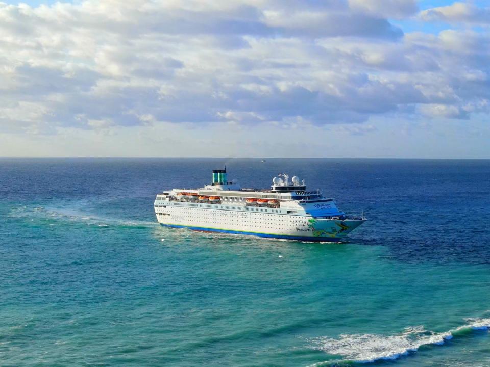 A Margaritaville branded cruise sailing near land.
