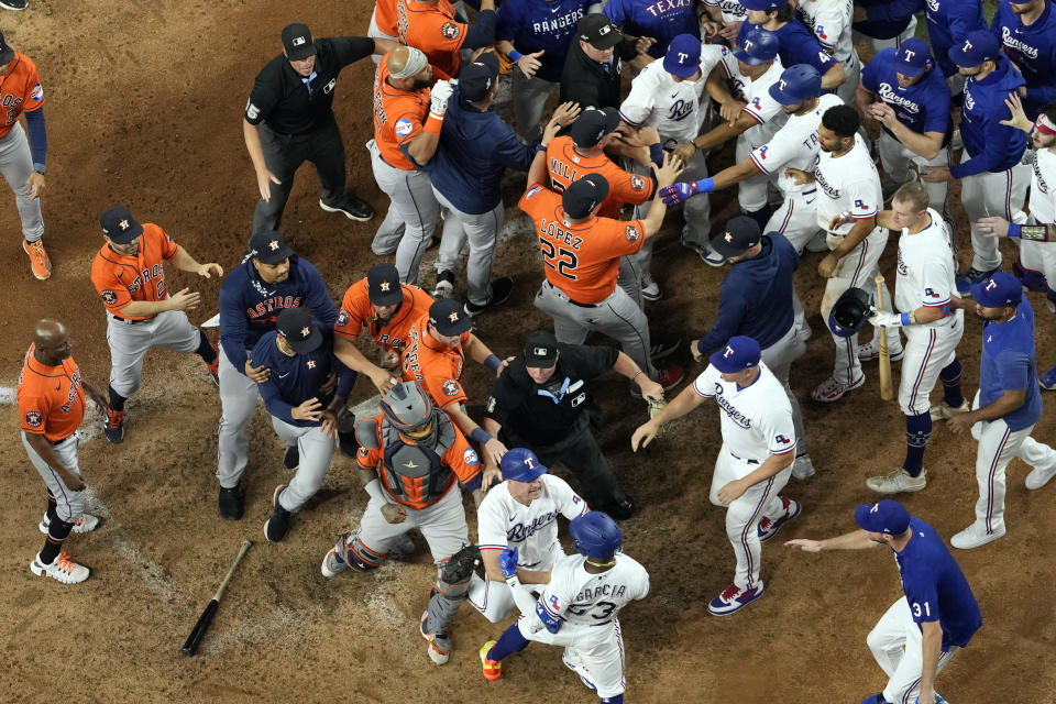 Players from Houston Astros and Texas Rangers clear the benches after Texas Rangers' Adolis Garcia was hit by a pitch thrown by Houston Astros relief pitcher Bryan Abreu during the eighth inning in Game 5 of the baseball American League Championship Series Friday, Oct. 20, 2023, in Arlington, Texas. (AP Photo/Godofredo A. Vásquez)