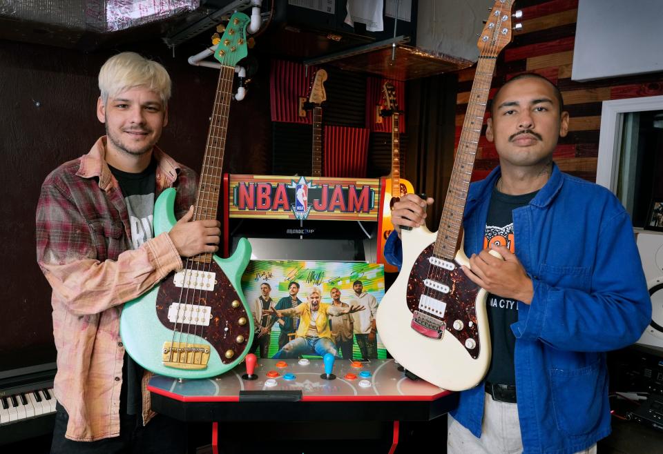 Rain City Drive members Colin Vieira and Felipe Sanchez, right, pose in front of a video game in the band's home studio in Palm Coast. When the musicians were starting out in teen bands they often played a video arcade in Palm Coast, where there weren't many clubs that featured music acts.