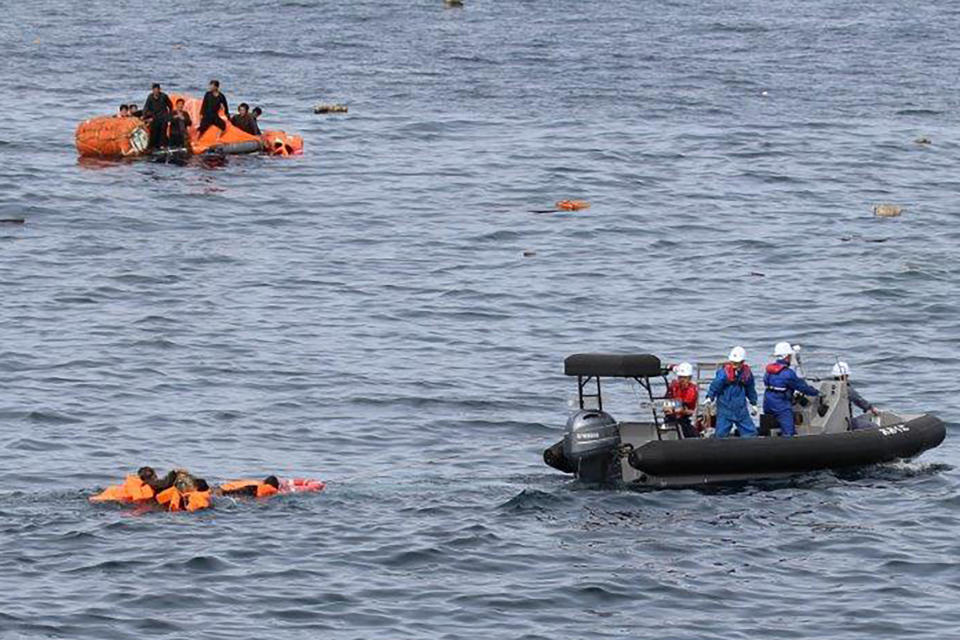 In this Monday, Oct. 7, 2019, photo released by Japan's Fisheries Agency, crew members, bottom right, of the agency work to rescue fishermen whose boat collided with a Japanese patrol vessel off the northwestern coast of the Noto Peninsula, Ishikawa prefecture, Japan. Japanese authorities said they rescued all of about 60 North Korean fishermen whose boat sank after the collision in an area crowded with poachers. (Fisheries Agency via AP)