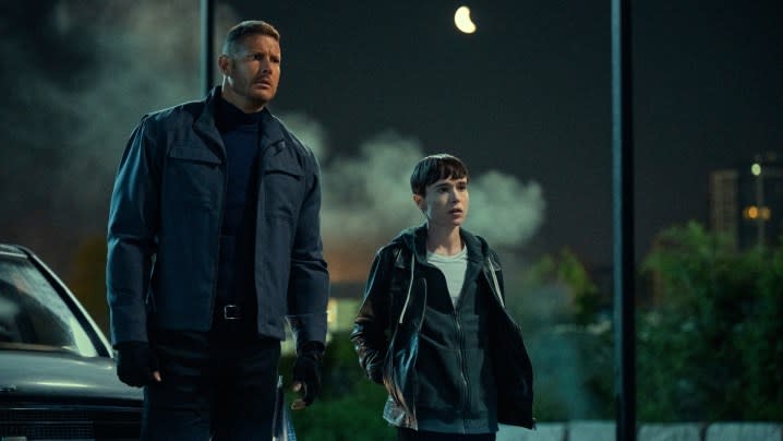 Tom Hopper and Elliot Page stand next to each other in a scene from season 3 of The Umbrella Academy.