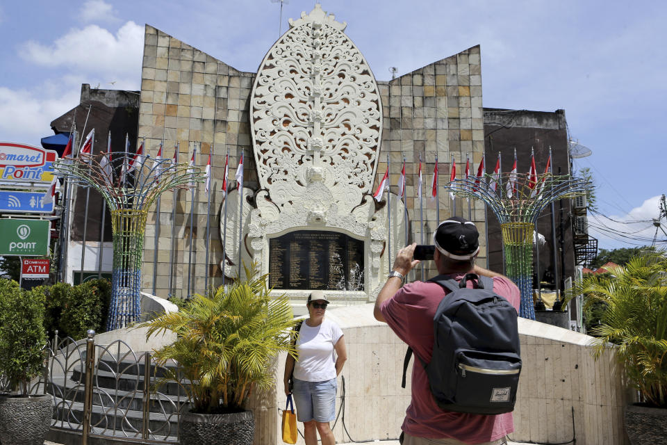 Foreign tourist take photographs at the Bali Bombing Memorial Monument in Kuta, Bali, Indonesia on Thursday, Dec. 8, 2022. An Islamic militant convicted of making the explosives used in the 2002 attack that killed over 200 people was paroled Wednesday, after serving about half of his original 20-year prison sentence, despite strong objections by Australia, which lost scores of citizens in the Indonesian attacks. (AP Photo/Firdia Lisnawati)