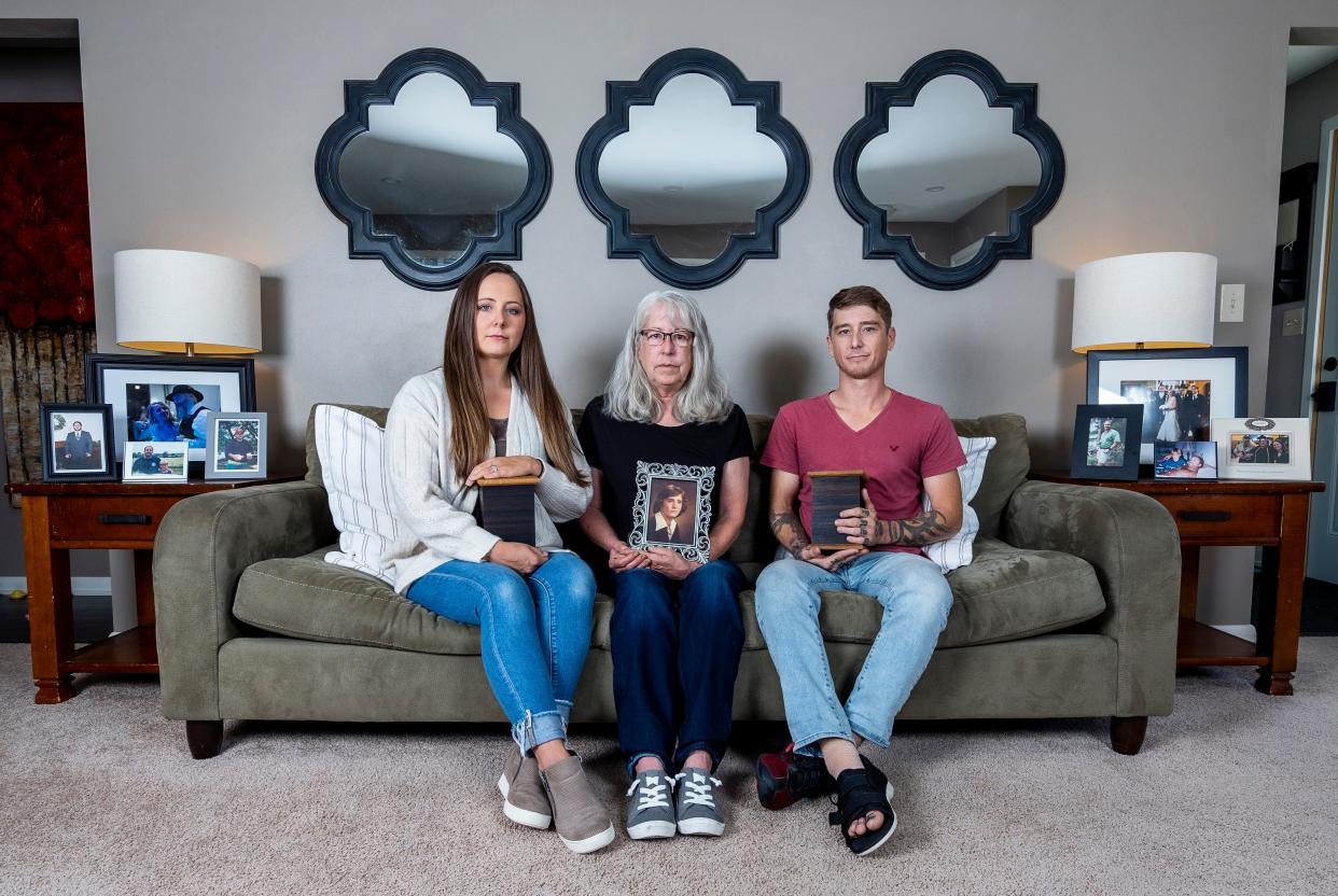 Deborah Hoffmann (center) holds a photo of Dean Hoffmann with her children Megan Kolb (left) and Barry Hoffmann (right) beside her in September 2023 in Cedarburg.