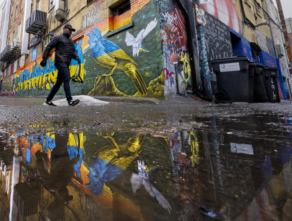 A man walks past a mural promoting peace in Ukraine in Graffiti Alley in Toronto on Monday, March 7, 2022. (Frank Gunn/The Canadian Press via AP)