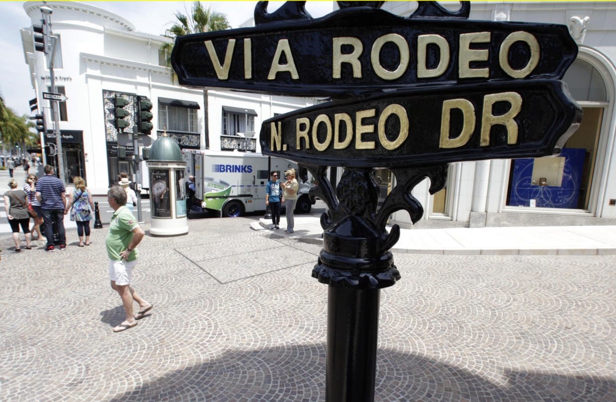 People stand along Rodeo Drive in Beverly Hills, California, May 21, 2013. Luxury spending in the United States collapsed after the financial crisis of 2008 but it has been roaring back since 2010 and returned to its pre-crisis levels in 2012. Photo taken May 21, 2013. To match Insight LUXURY-US/ REUTERS/Fred Prouser (UNITED STATES - Tags: BUSINESS SOCIETY WEALTH)