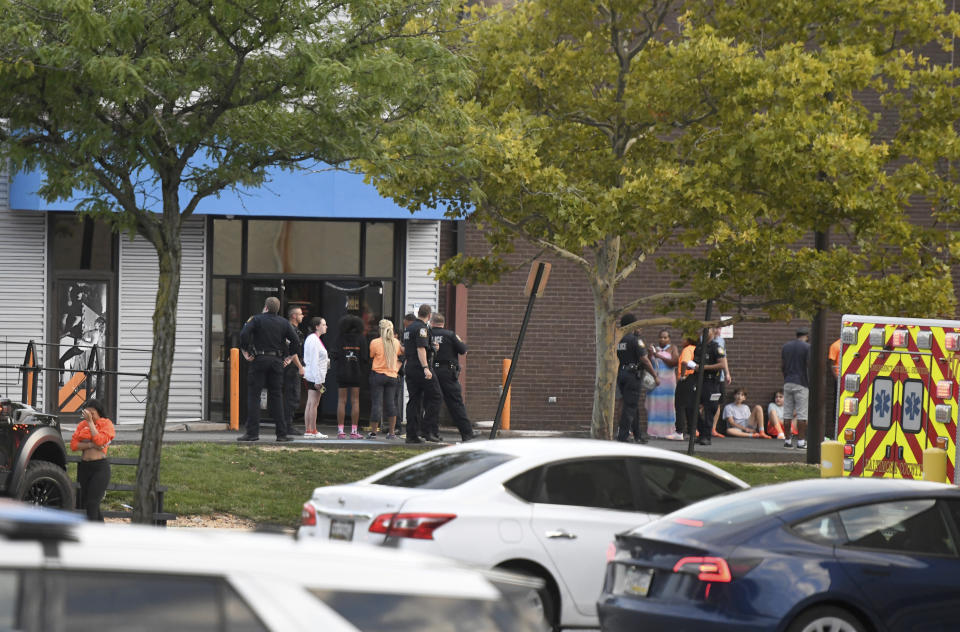 Baltimore County police and other people stand outside a Sky Zone trampoline park after shots were fired, according to police, in Timonium, Md., Saturday, Aug. 12, 2023. (AP Photo/Steve Ruark)