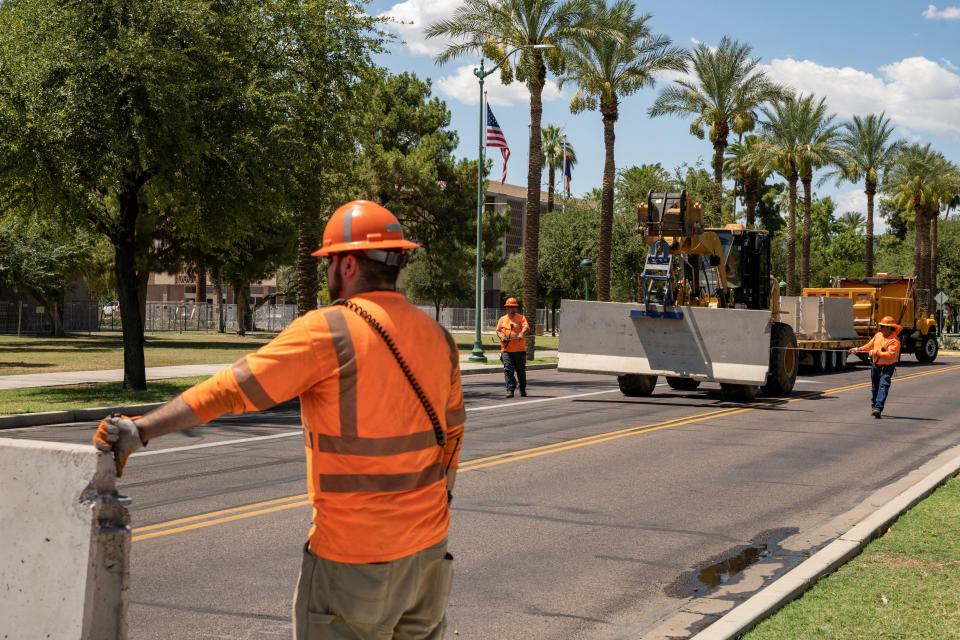 ADOT workers install concrete barriers in Phoenix, Arizona on June 27, 2022. REUTERS/Caitlin O’Hara