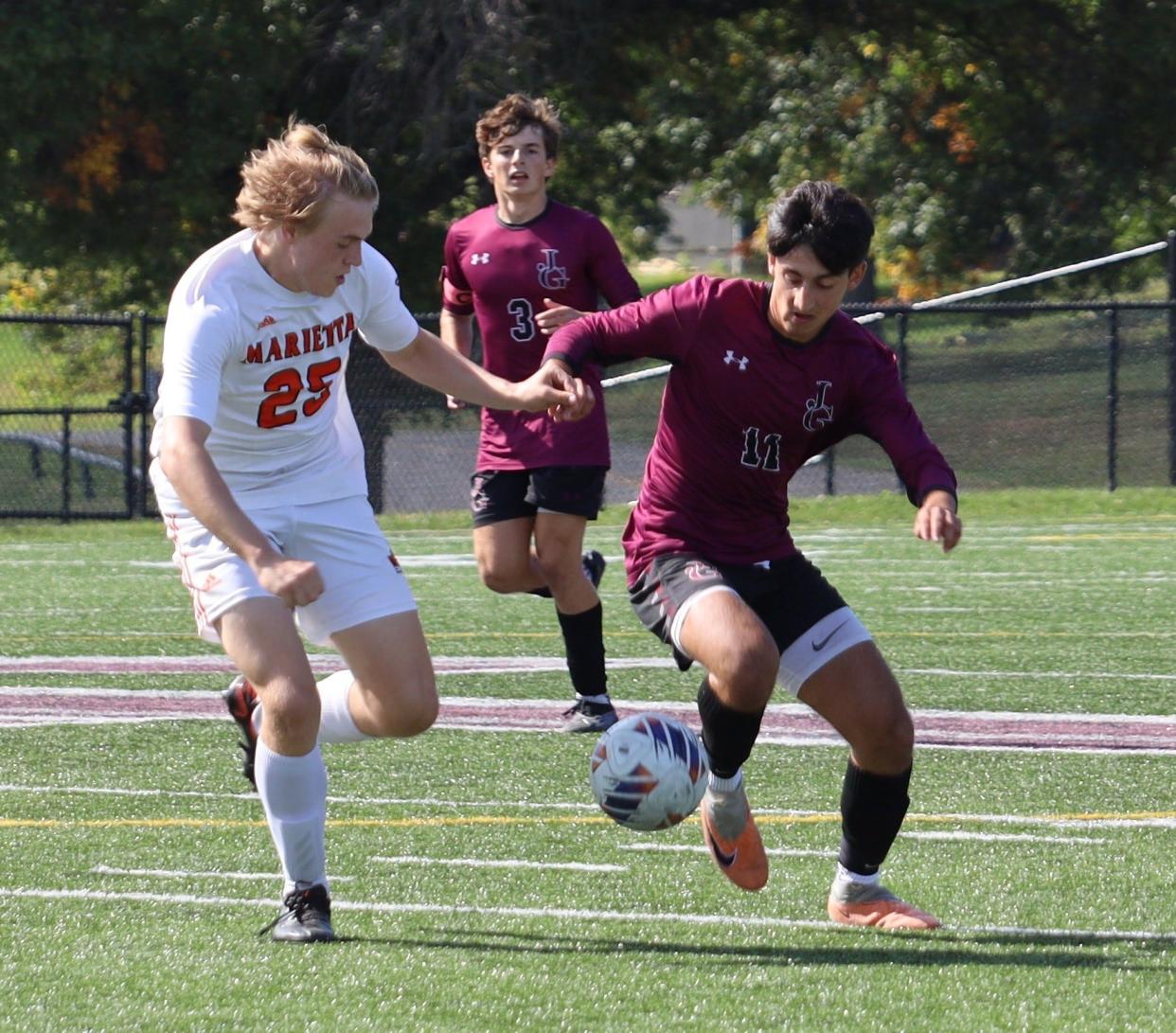 John Glenn's William Nicolozakes (11) dribbles the ball during against Marietta during a regular season match. Nicolozakes highlighted the boys soccer players on the East District First Team.