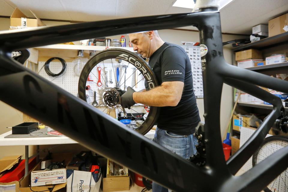 Tony Branco, owner of Scorpion Bike Wheels, puts the finishing touches on a set of carbon wheels he built for a customer, before installing them on the frame he is building seen in the background.  Mr. Branco started building high performance bicycle wheels in his basement and has now opened his own shop in the Jack Conway plaza on Route 6 in Dartmouth.