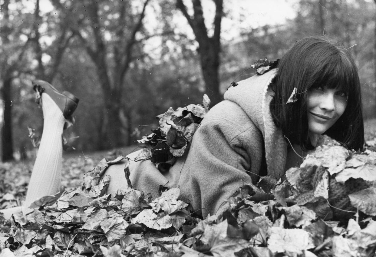 British Eurovision winner Sandie Shaw lies on the ground amongst autumn leaves