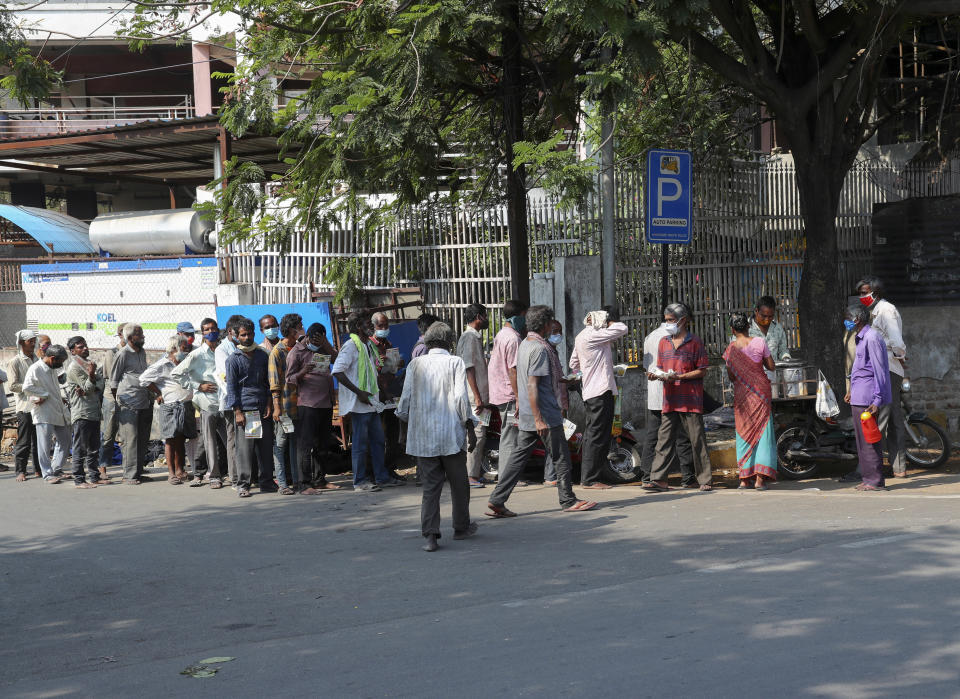 Homeless people queue up for free food being distributed by a charity in view of the COVID-19 pandemic in Hyderabad, India, Thursday, May 6, 2021. (AP Photo/Mahesh Kumar A.)