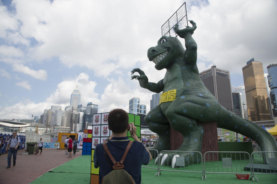 Visitator takes pictures to dinosaur giant sculpture, that is part of Lai Chi Kok amusement park, is seen in Central, Hong Kong, Jun. 29 2015. (Photo by Raul Ariano/NurPhoto) (Photo by NurPhoto/NurPhoto via Getty Images)