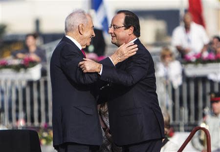 French President Francois Hollande (R) and his Israeli counterpart Shimon Peres greet each other during the official reception upon Hollande's arrival at Ben Gurion airport near Tel Aviv November 17, 2013. Hollande arrived on Sunday for a three-day state visit to Israel and the Palestinian Territories. REUTERS/Nir Elias