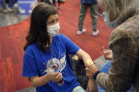 Jehna Kottori, 10, of Worcester, Mass., prepares to receive a shot of the Pfizer COVID-19 vaccine, Thursday, Dec. 2, 2021, at a mobile vaccination clinic in Worcester. As the U.S. recorded its first confirmed case of the omicron variant, doctors across the country are experiencing a more imminent crisis with a delta variant that is sending record numbers of people to the hospital in New England and the Midwest. (AP Photo/Steven Senne)