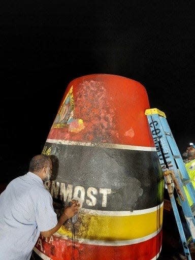 Workers restore Key West's Southernmost Point Buoy, which was burned on New Year's Day. Two suspects - one from Leesburg - are set to turn themselves in, according to the Key West Police Department.