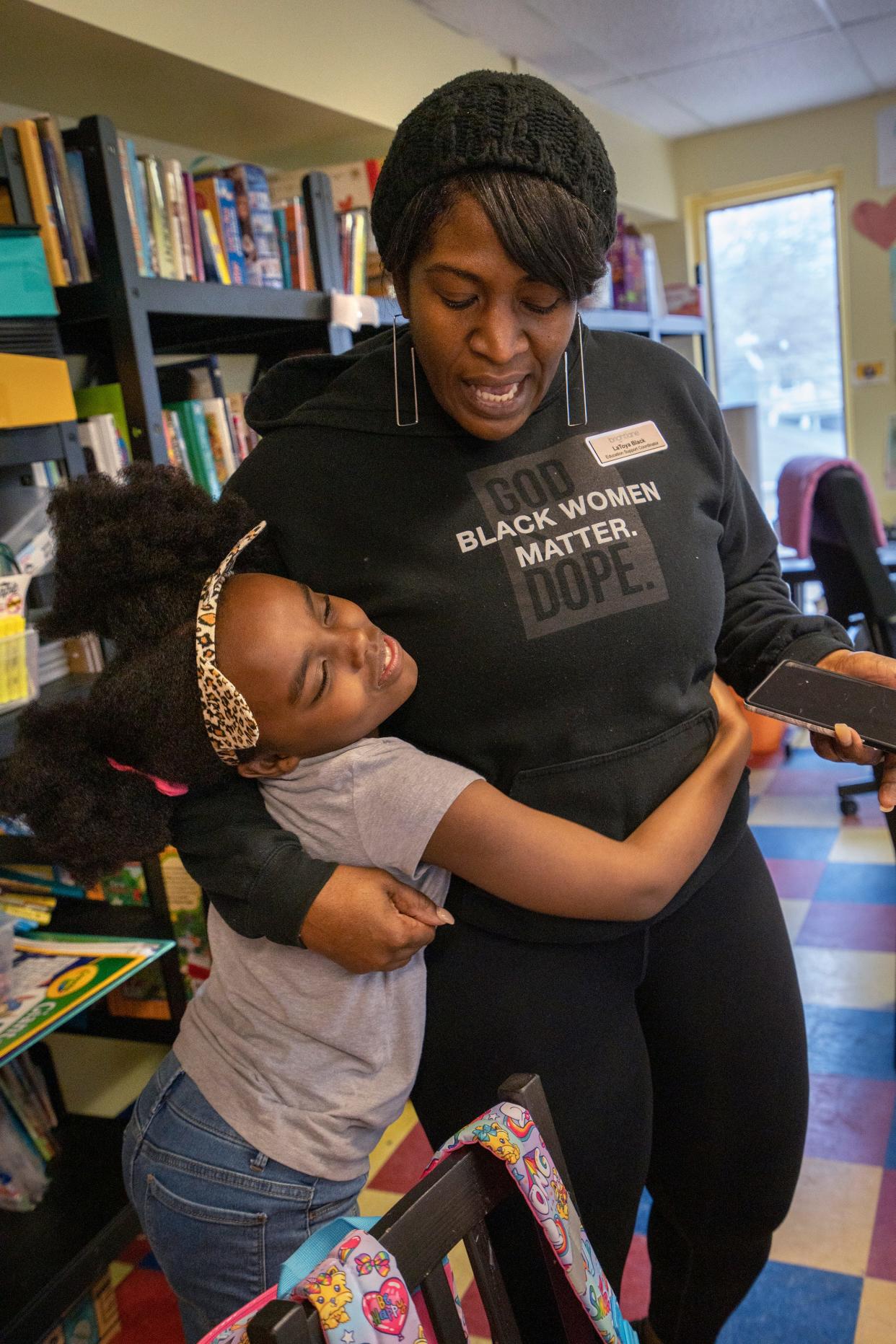 Rosetta Walker, left, gets a big hug from Brightlane Education Support Coordinator LaToya Black who presents her with headphones Tuesday, Feb. 7, 2023 at Dayspring Center. Brightlane volunteers tutor the kids in the shelter. Rosetta lives there with her mother, Doris Jones, and her sister, Samantha Hillard.