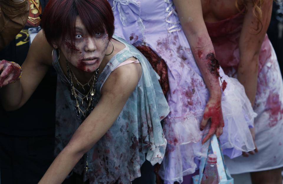 Participants wearing costumes and make-up as zombies march during a Halloween event to promote the U.S. TV series "The Walking Dead" at Tokyo Tower