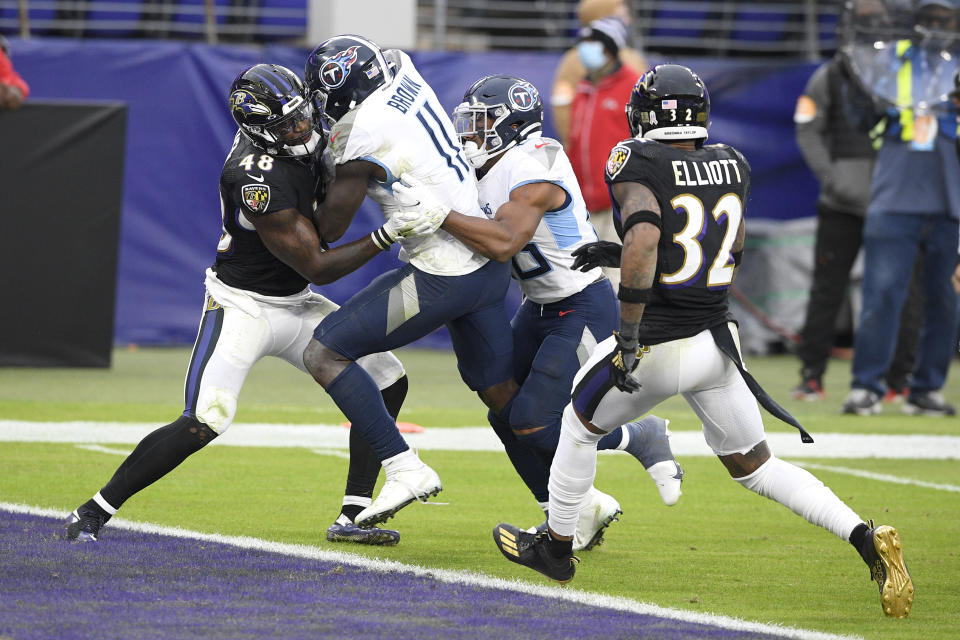 Tennessee Titans wide receiver A.J. Brown (11) gets help from teammate running back Jeremy McNichols, center right, while scoring against Baltimore Ravens inside linebacker Patrick Queen (48) and free safety DeShon Elliott (32) during the second half of an NFL football game, Sunday, Nov. 22, 2020, in Baltimore. (AP Photo/Nick Wass)