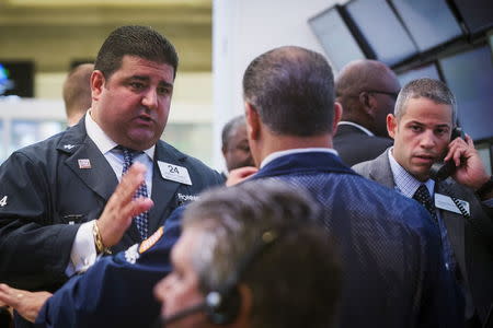 Traders, governors, and members of the New York Stock Exchange discuss what is happening following a halt in trading on the floor of the exchange in New York, July 8, 2015. REUTERS/Lucas Jackson