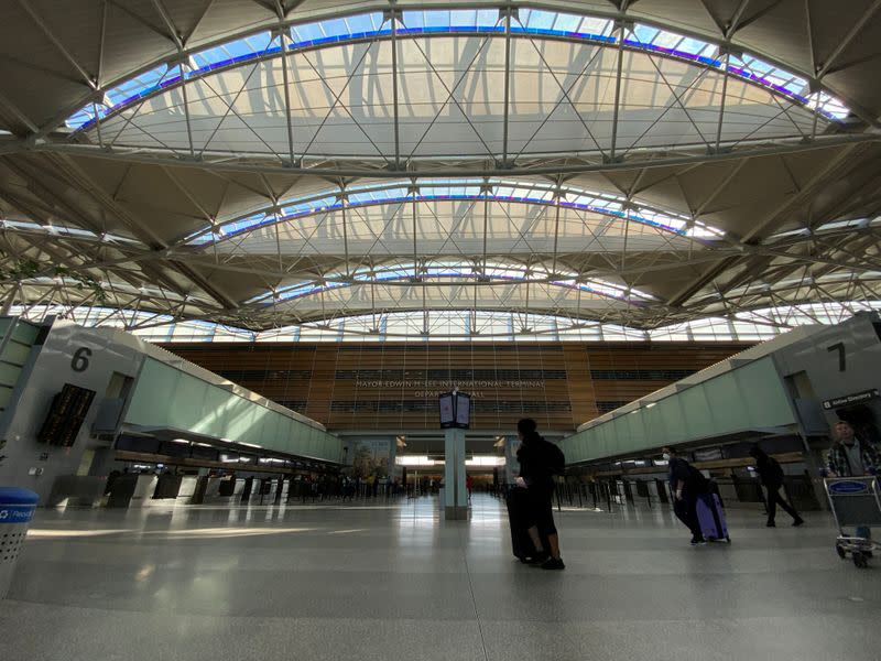 FILE PHOTO: A view of a handful of travellers, many in protective masks amid coronavirus disease (COVID-19) outbreak, at the departures hall of the San Francisco International Airport in San Francisco