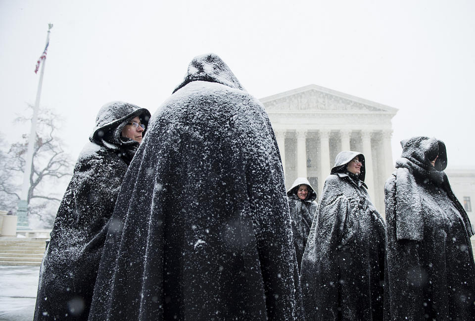 Snow-covered nuns from the Fraternite Notre Dame in Chicago stand in front of the U.S. Supreme Court on the anniversary of Roe v. Wade Friday, Jan. 22, 2016, following the annual March for Life. Snow began to fall early afternoon as approaching blizzard conditions threatens to shut down the Washington area.