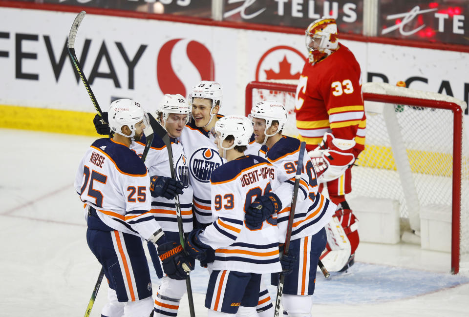 Edmonton Oilers Jesse Puljujarvi (13) celebrates his goal with teammates Darnell Nurse (25), Tyson Barrie (22), Ryan Nugent-Hopkins (93) and Connor McDavid (97) as Calgary Flames goalie David Rittich looks on during the first period of an NHL hockey game, Friday, Feb. 19, 2021 in Calgary, Alberta. (Todd Korol/The Canadian Press via AP)