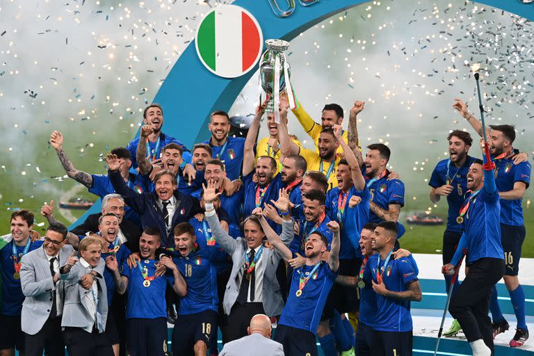 El defensa italiano Giorgio Chiellini (C) levanta el trofeo del Campeonato de Europa durante la presentación después de que Italia ganara el partido de fútbol final de la UEFA EURO 2020 entre Italia e Inglaterra en el estadio de Wembley en Londres el 11 de julio de 2021.